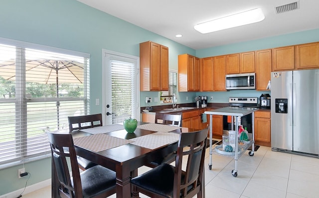 kitchen featuring appliances with stainless steel finishes, sink, and light tile patterned flooring