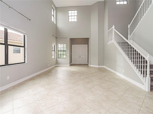 tiled foyer with a towering ceiling