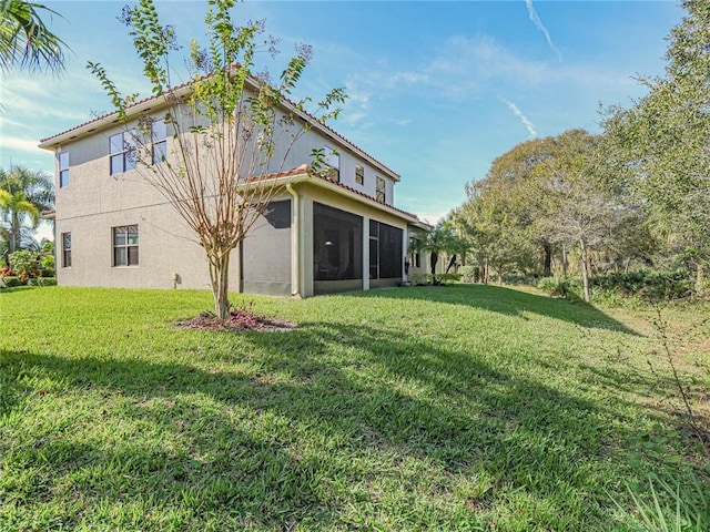 back of house with a yard and a sunroom