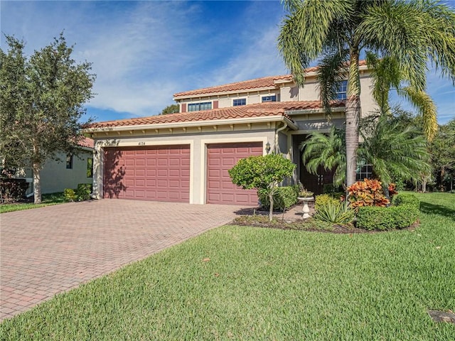 mediterranean / spanish home featuring a garage and a front yard