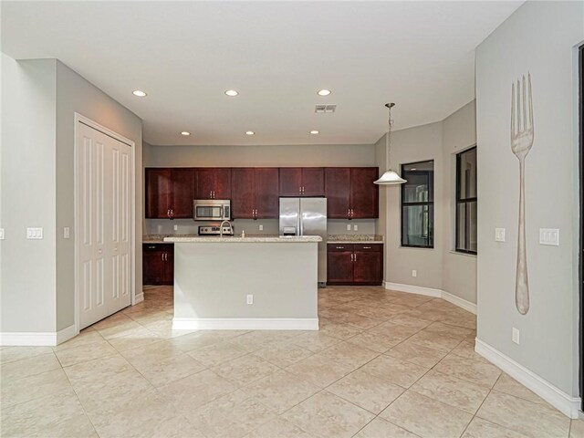 kitchen featuring stainless steel appliances, light stone counters, pendant lighting, a center island with sink, and light tile patterned floors