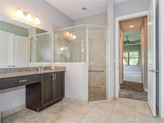 bathroom featuring tile patterned flooring, ceiling fan, a shower with door, and vanity