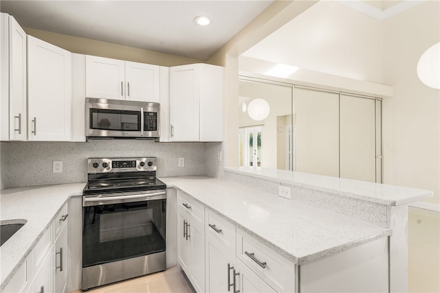 kitchen with stainless steel appliances, white cabinetry, and kitchen peninsula