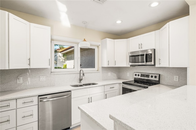 kitchen with stainless steel appliances, hanging light fixtures, white cabinetry, and sink