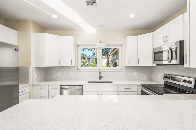 kitchen featuring white cabinetry, stainless steel appliances, sink, and pendant lighting