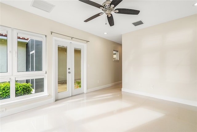 empty room featuring light tile patterned flooring, ceiling fan, and french doors