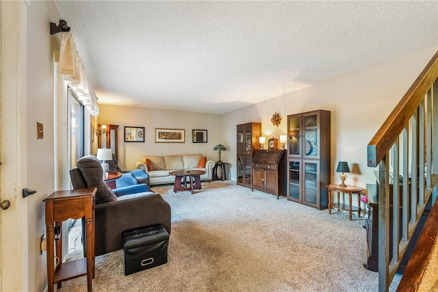 living room with stairs, a textured ceiling, and carpet