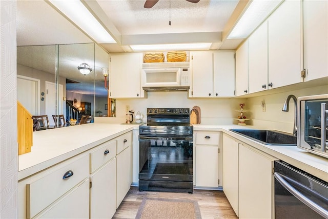 kitchen with white microwave, black range with electric cooktop, white cabinetry, light countertops, and dishwasher