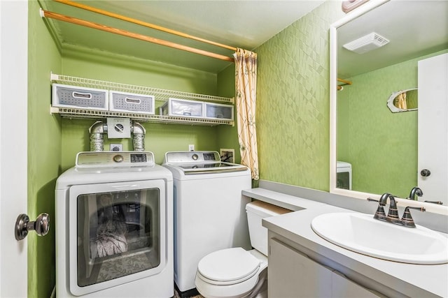 bathroom with toilet, vanity, visible vents, and washer and dryer