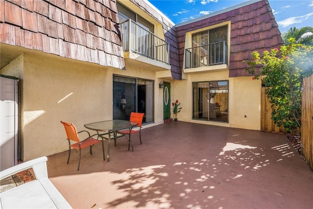 rear view of property with a balcony and a patio