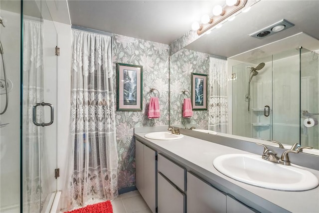 full bathroom with double vanity, a sink, and wallpapered walls