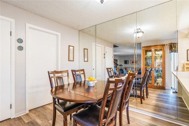 dining room featuring a textured ceiling and wood finished floors