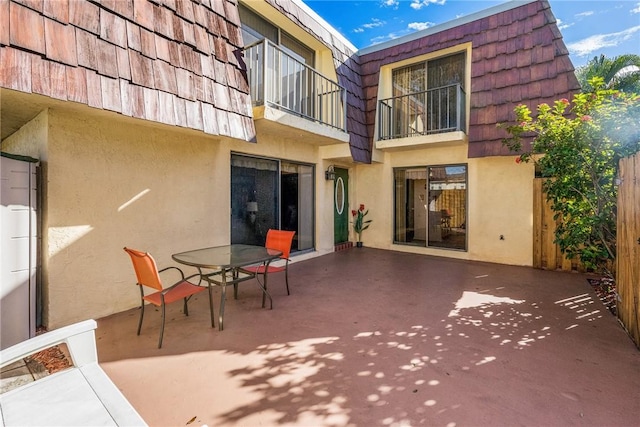 1170 6th Ave Unit 10A, Vero Beach, FL 32960 - back of property featuring stucco siding, mansard roof, a balcony, and a patio