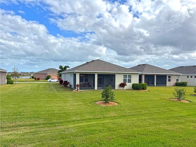 rear view of property with a sunroom and a lawn