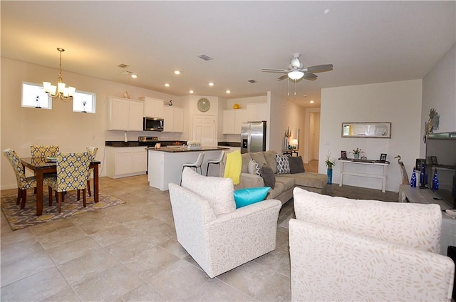 living room with ceiling fan with notable chandelier