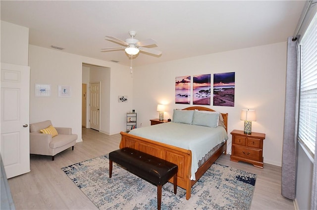 bedroom featuring light wood-type flooring, multiple windows, and ceiling fan