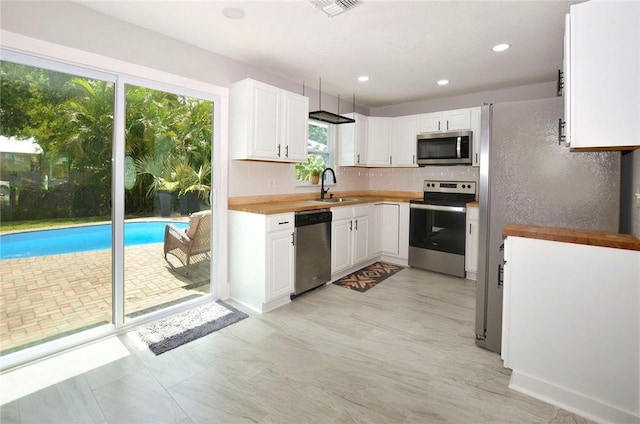 726 41st Ave, Vero Beach, FL 32968 - kitchen featuring appliances with stainless steel finishes, a sink, white cabinets, decorative backsplash, and recessed lighting