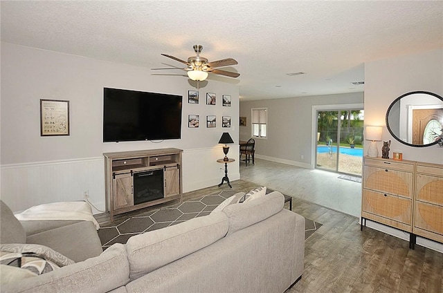 726 41st Ave, Vero Beach, FL 32968 - living area with wood finished floors, a ceiling fan, a textured ceiling, and a wainscoted wall
