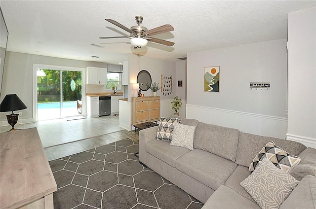 726 41st Ave, Vero Beach, FL 32968 - living area featuring ceiling fan, dark wood-style flooring, a textured ceiling, and wainscoting