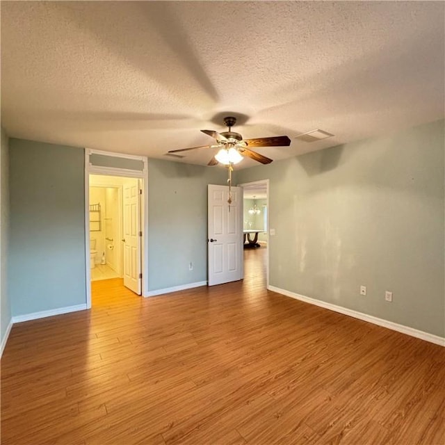 spare room with visible vents, baseboards, ceiling fan, and wood finished floors