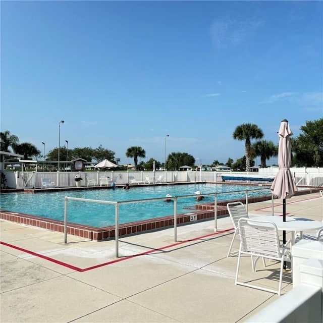 view of swimming pool featuring fence