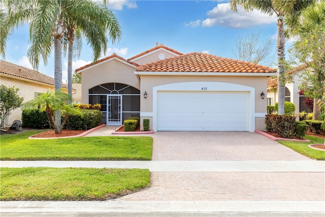 mediterranean / spanish-style home with a front yard and a garage