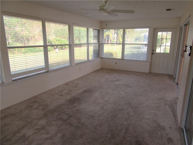 unfurnished sunroom with ceiling fan