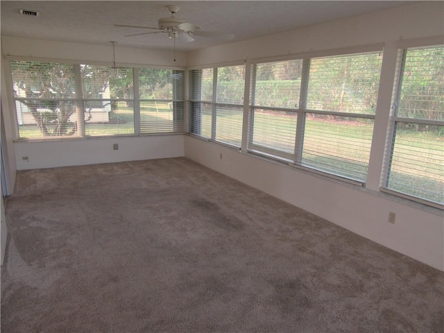 unfurnished sunroom with ceiling fan