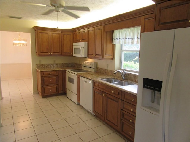 kitchen with light tile patterned floors, ceiling fan, white appliances, light stone counters, and sink