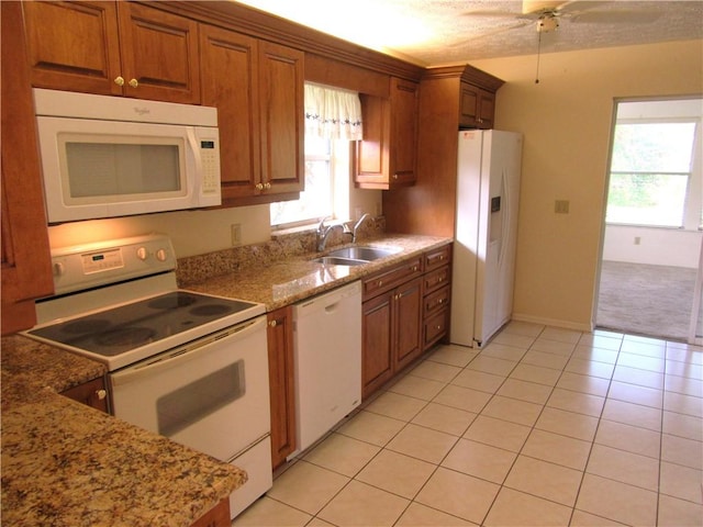 kitchen with light stone countertops, sink, white appliances, and light tile patterned flooring