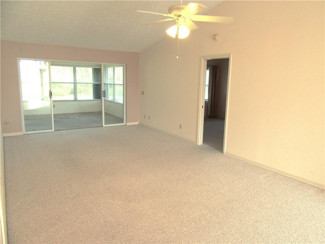 spare room with lofted ceiling, light colored carpet, and ceiling fan