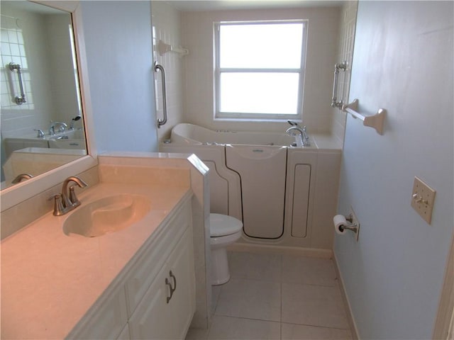 bathroom with toilet, vanity, a bathtub, and tile patterned floors