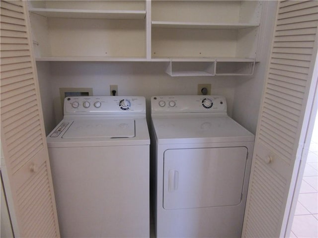 clothes washing area with washer and dryer and light tile patterned flooring