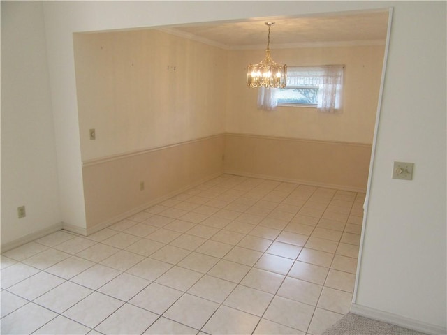 spare room featuring light tile patterned floors, a notable chandelier, and crown molding