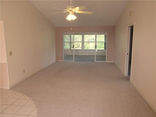 spare room featuring ceiling fan, light colored carpet, and lofted ceiling