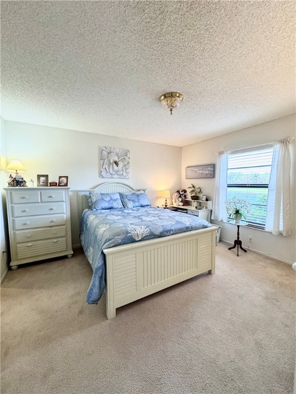 bedroom featuring a textured ceiling and light carpet