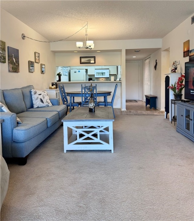 living room with an inviting chandelier, carpet, and a textured ceiling