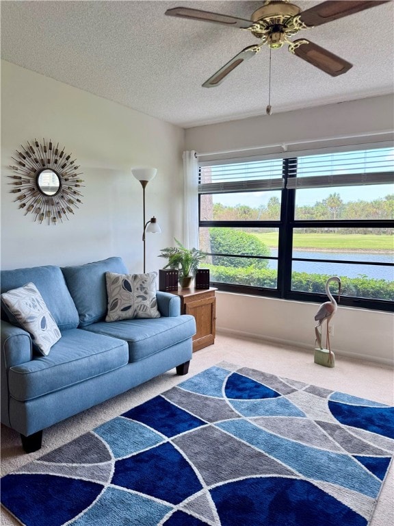 living room with a textured ceiling, carpet, and ceiling fan