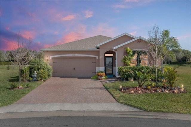 ranch-style home featuring a garage and a yard