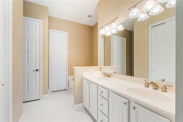 bathroom with a sink, a bath, double vanity, and tile patterned flooring