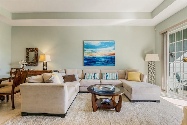 tiled living area with a tray ceiling