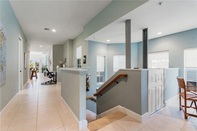 hallway featuring visible vents, baseboards, an upstairs landing, light tile patterned floors, and recessed lighting