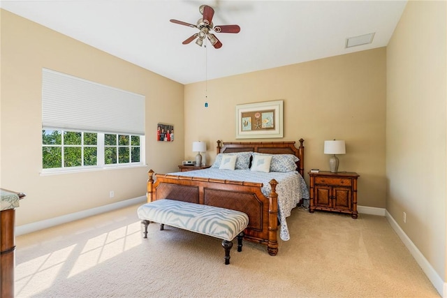 bedroom featuring visible vents, light colored carpet, a ceiling fan, and baseboards