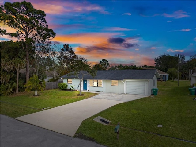 ranch-style home with a garage and a yard