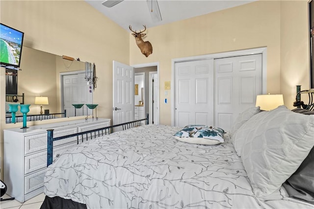 tiled bedroom with vaulted ceiling, ceiling fan, and a closet