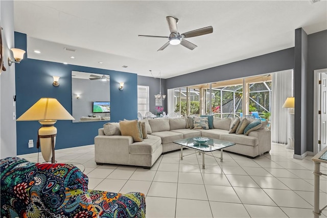 tiled living room featuring ceiling fan with notable chandelier