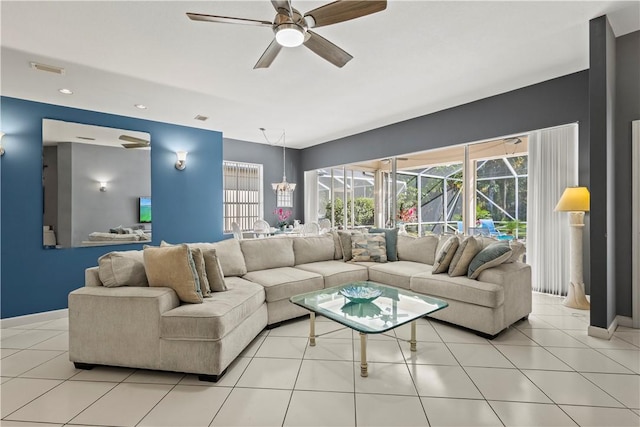 tiled living room with ceiling fan with notable chandelier