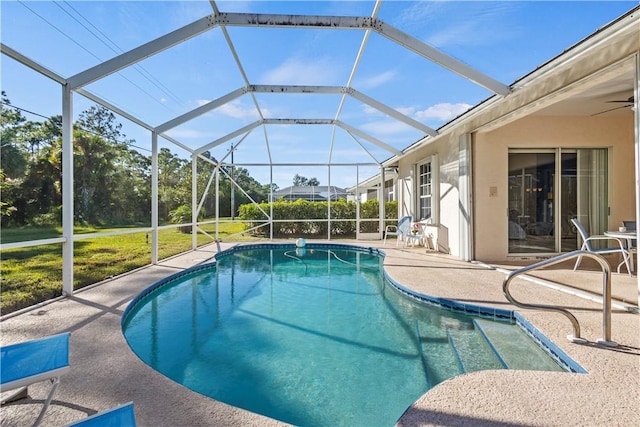 view of swimming pool featuring a patio, ceiling fan, and glass enclosure