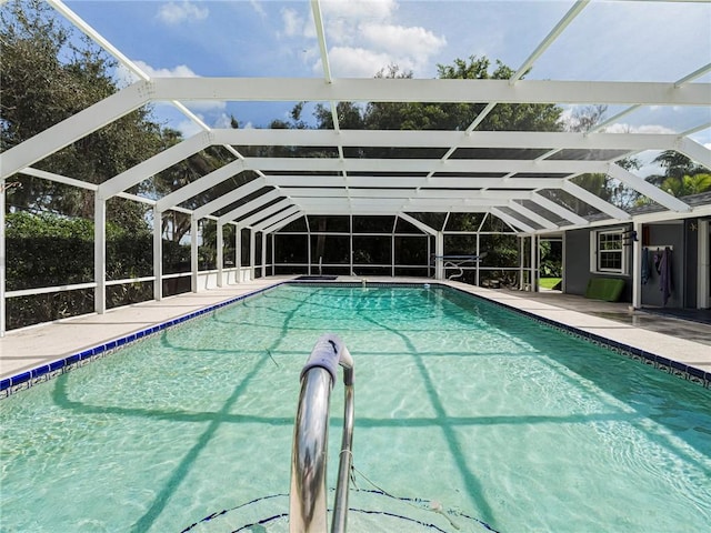 outdoor pool with glass enclosure and a patio area