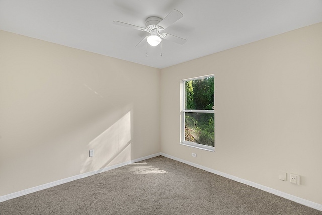 carpeted spare room featuring ceiling fan